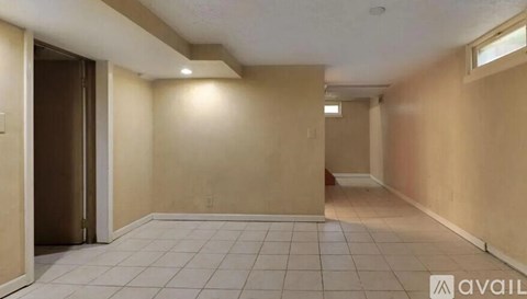 A spacious room with beige walls and a tiled floor.