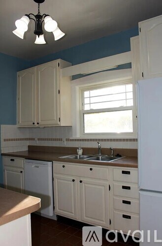 A kitchen with white cabinets and a window.