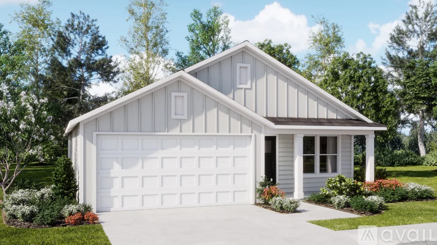 A two-car garage with a white door is surrounded by a well-manicured lawn and trees.