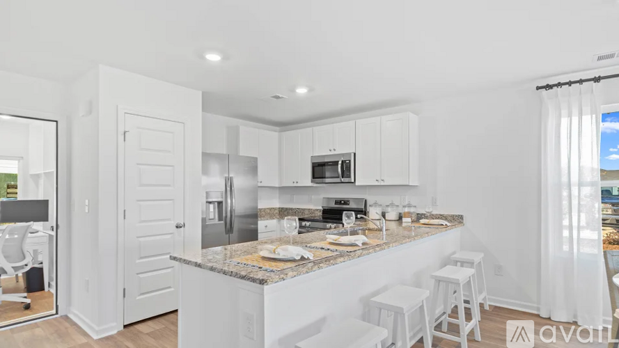 A kitchen with white cabinets and a granite countertop.