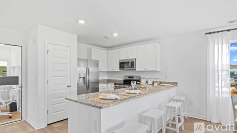 A kitchen with white cabinets and a granite countertop.