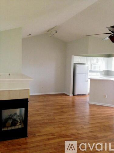 A living room with a fireplace and a ceiling fan.