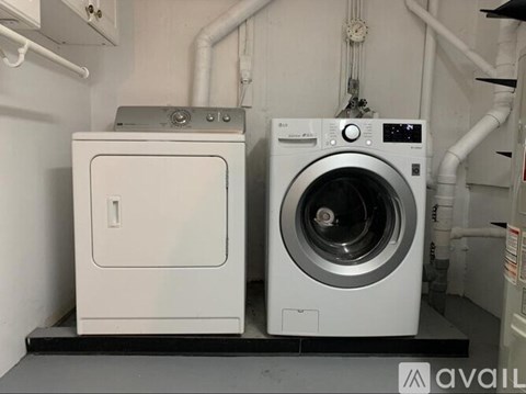 A washing machine and dryer are on display in a laundry room.