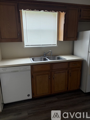 A kitchen with wooden cabinets and a white dishwasher.