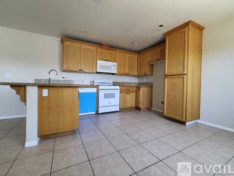 A kitchen with wooden cabinets and a white refrigerator.
