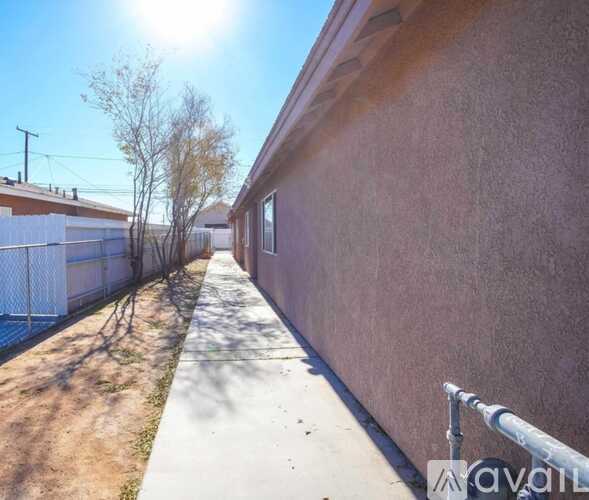 A sunny day with a clear blue sky and a building with a brown wall.