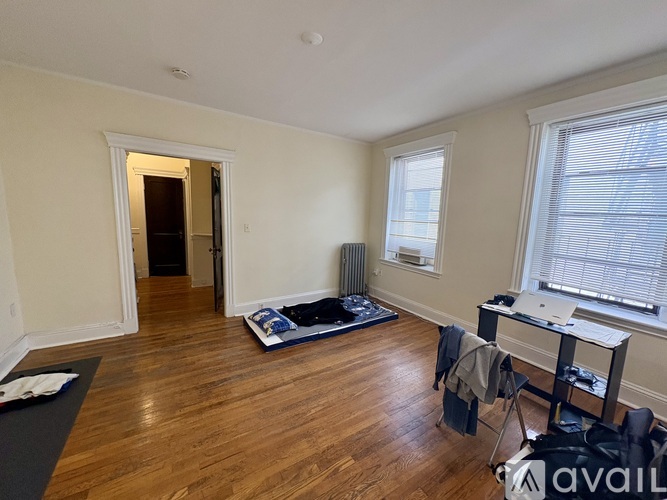 A room with wooden floors and a desk with a laptop on it.