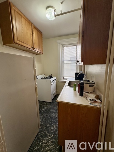 A kitchen with wooden cabinets and a white fridge.
