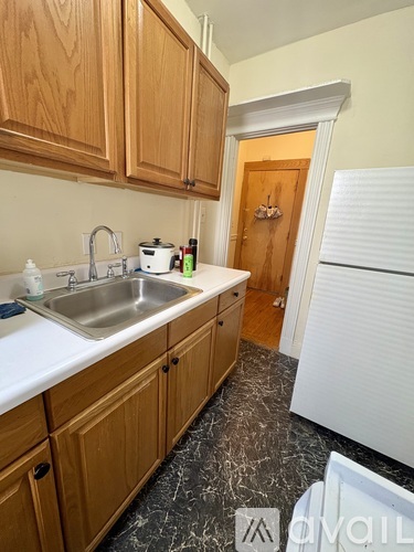 A kitchen with wooden cabinets and a white fridge.
