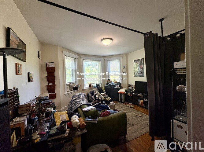 A living room with a couch, a chair, a coffee table, and a television.