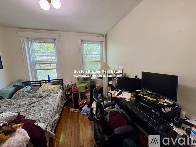 A bedroom with a bed, desk, and chair.