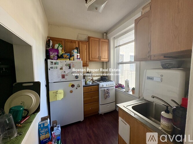 A kitchen with a white fridge and wooden cabinets.