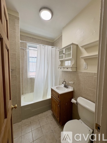 A bathroom with a toilet, sink, and shower.