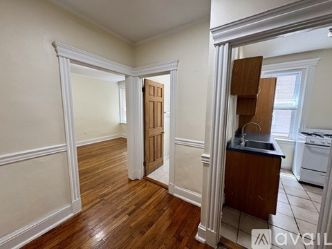 A kitchen area with a sink and a wooden door.