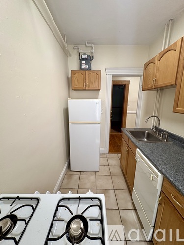 A kitchen with a white fridge and a stove top.