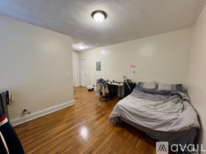 A bedroom with a bed, desk, and chair.