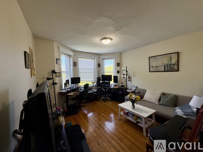 A living room with a couch, chairs, and a television.