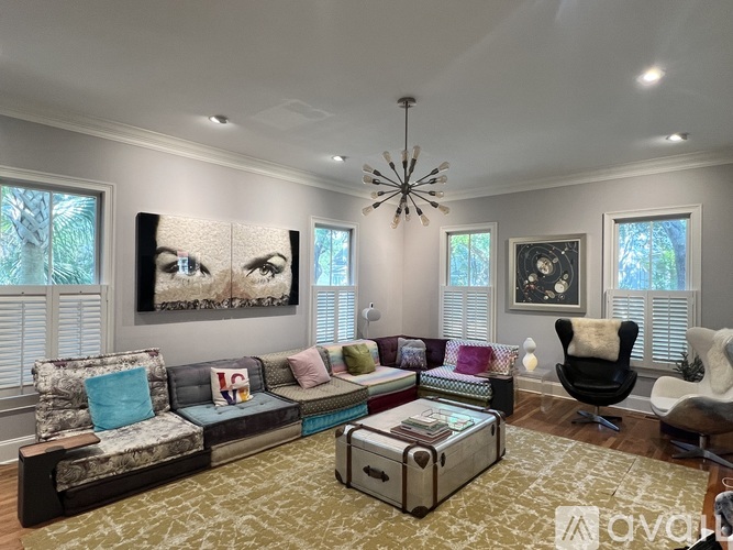 A living room with a large couch and a chandelier.
