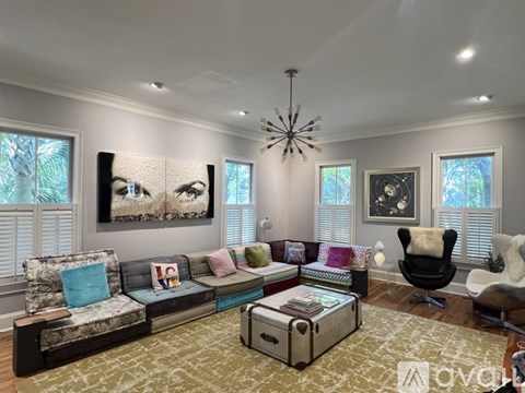 A living room with a large couch and a chandelier.