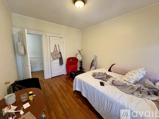 A bedroom with a bed, a table, and a chair.