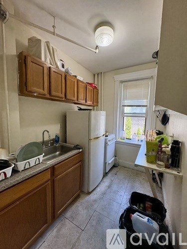 A kitchen with wooden cabinets and a white fridge.