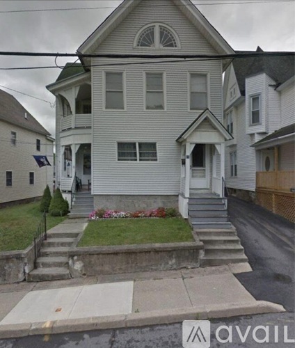 A two-story house with a front porch and a small front yard.