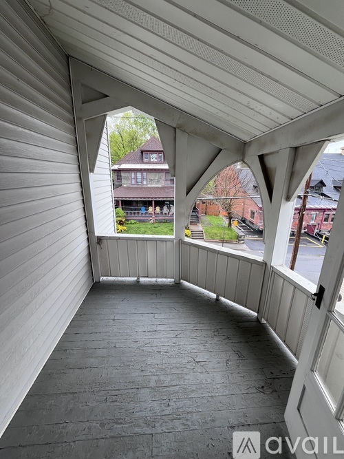 A balcony with a view of a house and trees.