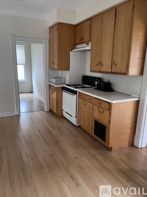 A kitchen with wooden cabinets and a white stove top oven.
