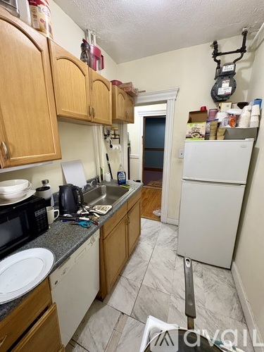 A kitchen with wooden cabinets and a white refrigerator.