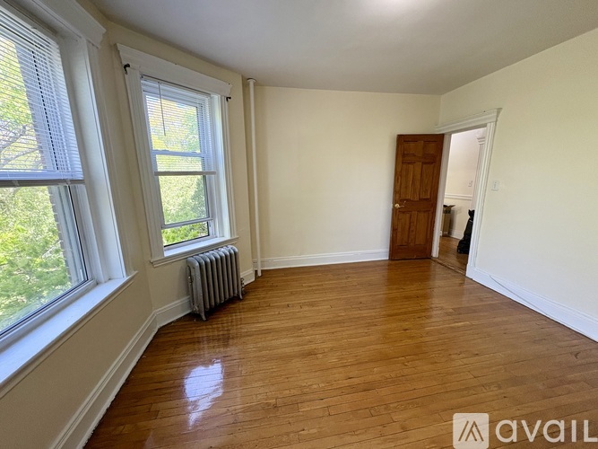 A room with wooden floors and a window with blinds.