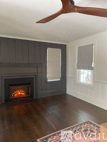 A room with a fireplace and a fan.