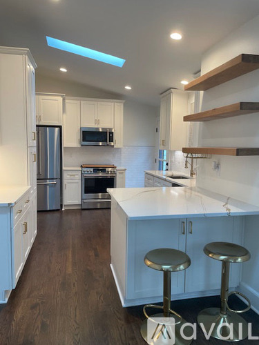 A kitchen with white cabinets and a white counter top.