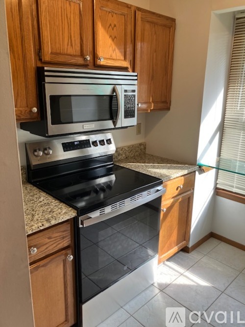 A kitchen with wooden cabinets and a black stove top oven.