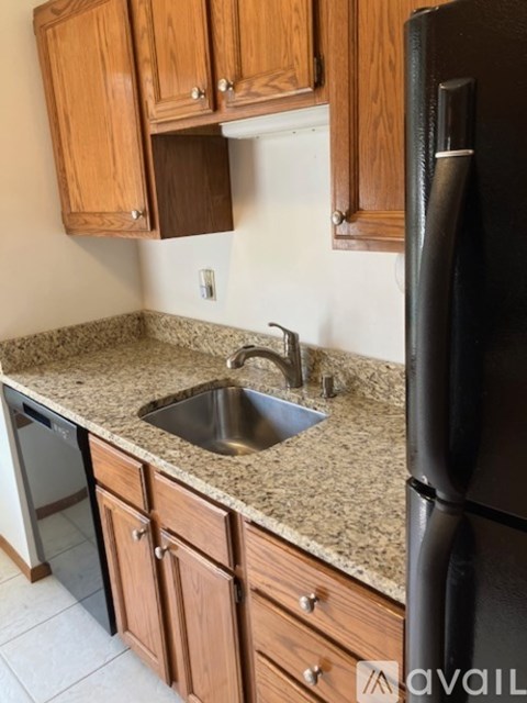A kitchen with a sink and a refrigerator.