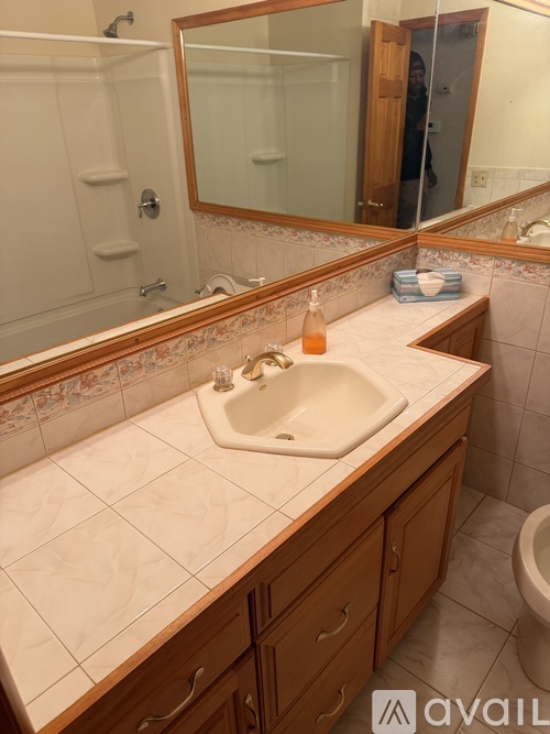 A bathroom with a sink, mirror, and toilet.