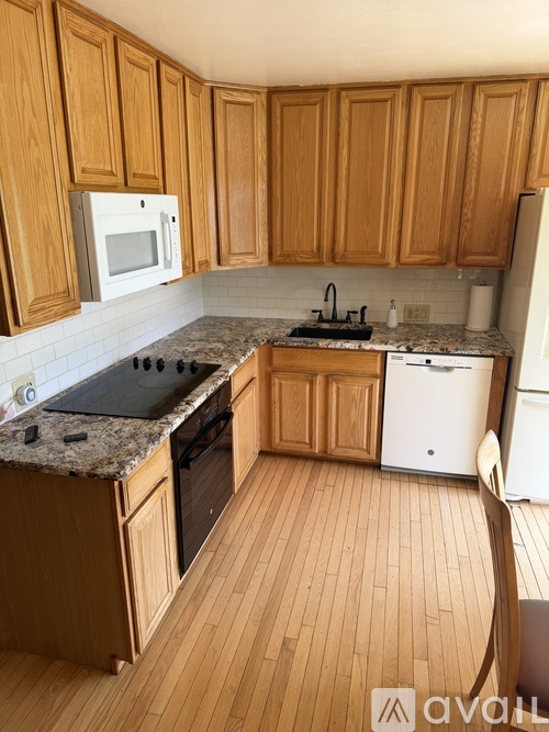 A kitchen with wooden cabinets and a granite countertop.