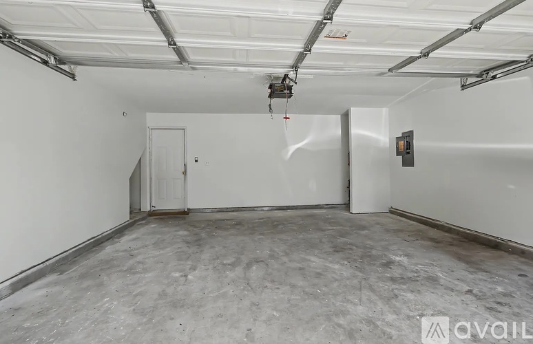 A spacious garage with a concrete floor and white walls.