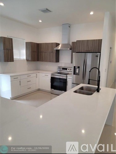 A modern kitchen with white countertops and brown cabinets.