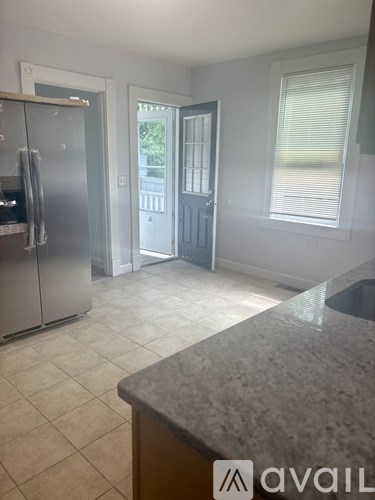 A kitchen with a granite counter and a refrigerator.