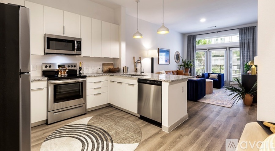A modern kitchen with white cabinets and stainless steel appliances.
