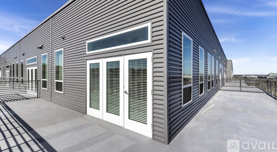 A modern building with a corrugated metal exterior and a row of windows.
