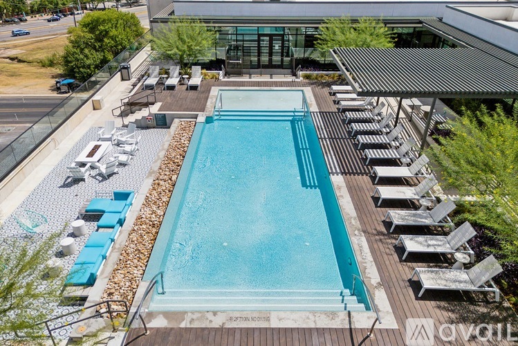 A large outdoor swimming pool surrounded by sun loungers.