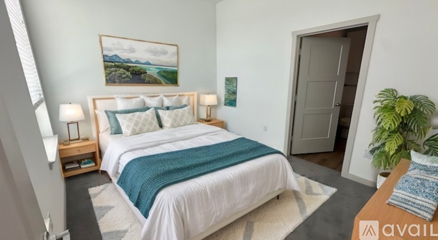 A bedroom with a large bed and a painting on the wall.