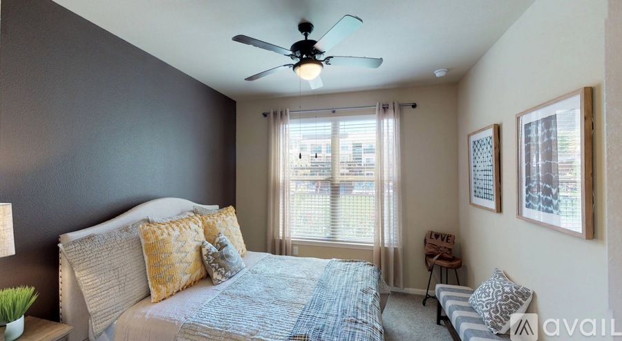 A bedroom with a bed, a ceiling fan, and a window with blinds.