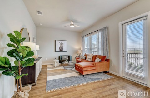 A living room with a brown couch and a large painting on the wall.