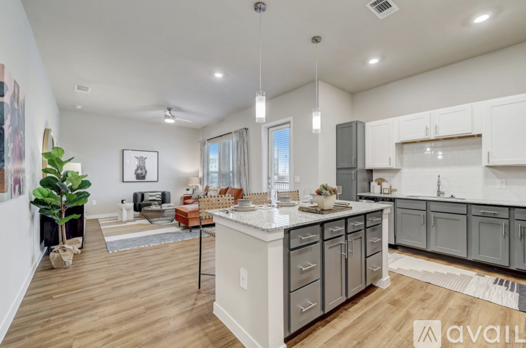 A modern kitchen with white cabinets and a wooden floor.