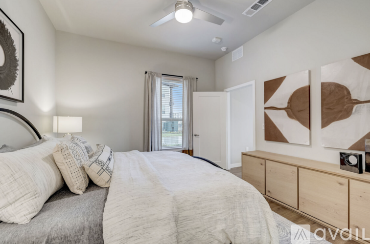 A bedroom with a large bed and a painting on the wall.