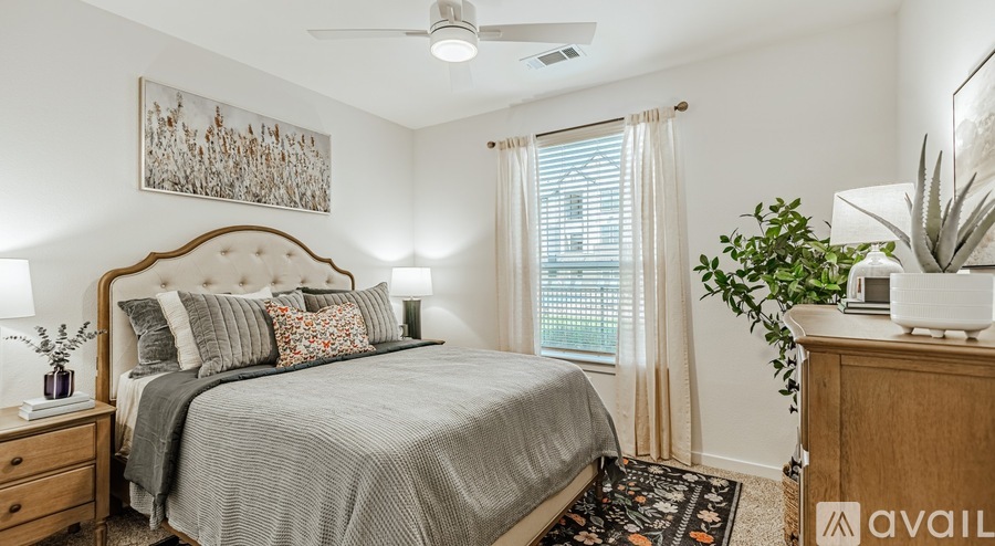 A well-lit bedroom with a large bed and a ceiling fan.