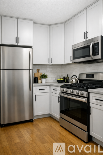 A kitchen with a stainless steel refrigerator, oven, and microwave.