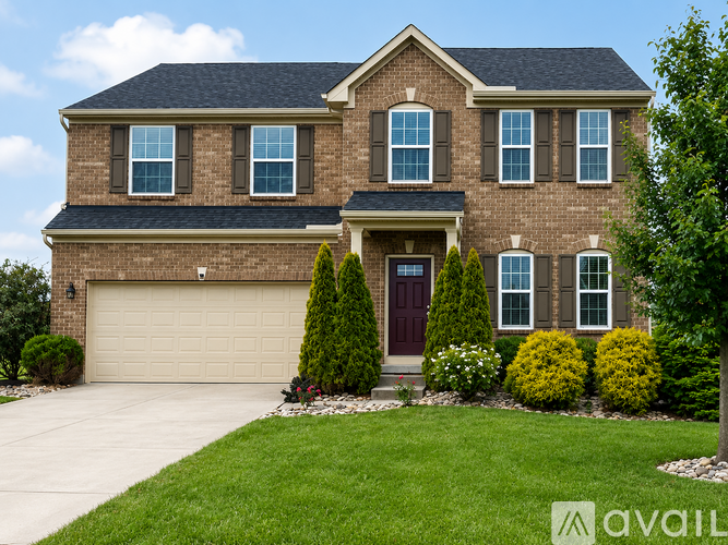 A large house with a brown brick exterior and a dark brown door.